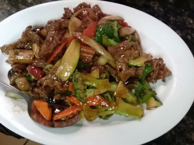 Hunan Beef: sliced beef stir fried with straw mushrooms, carrots, baby corn, green pepper, broccoli, and celery in a brown sauce.